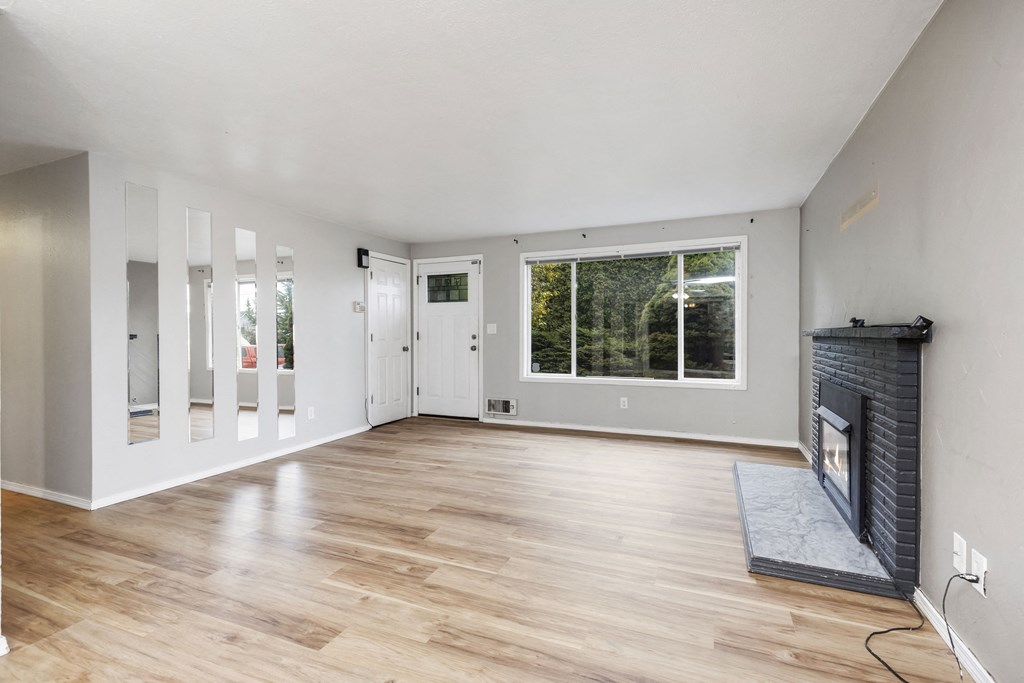 an empty living room with a fireplace and a window