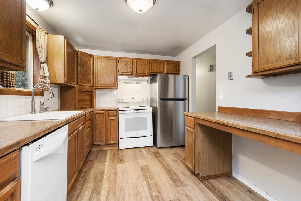 a kitchen with wooden cabinets and stainless steel appliances
