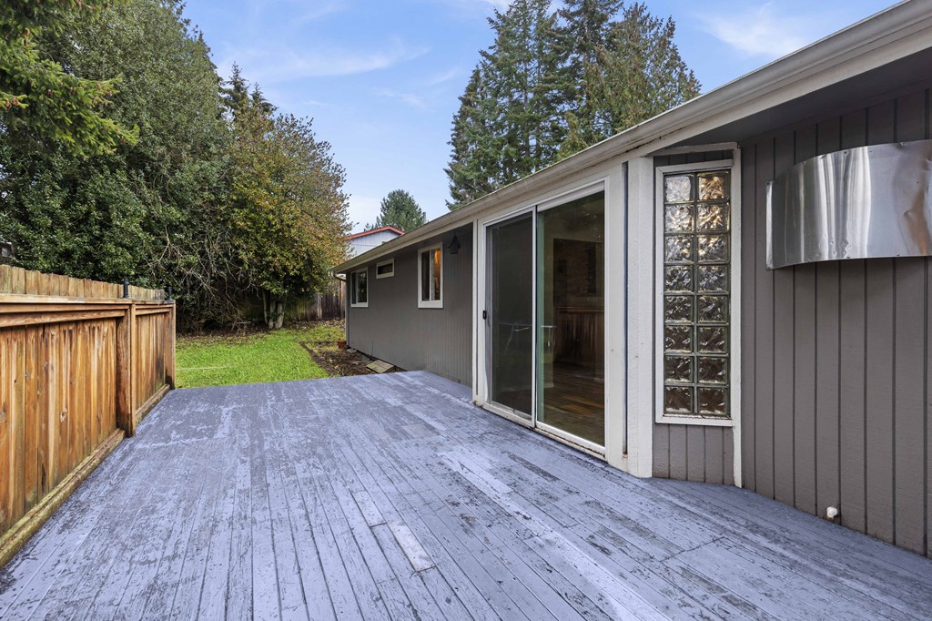 a backyard with a wooden deck and a sliding glass door