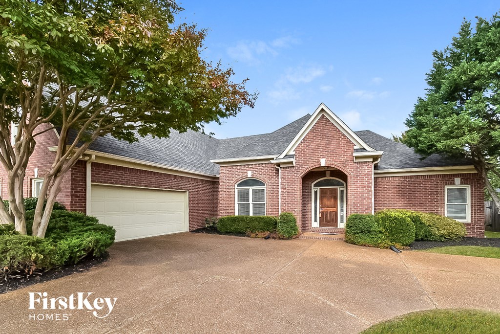 A brick house with a garage door is for sale.