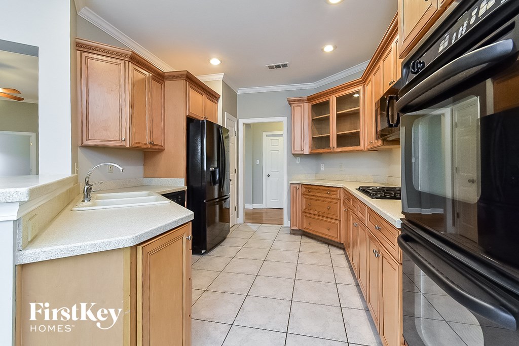A kitchen with wooden cabinets and black appliances.
