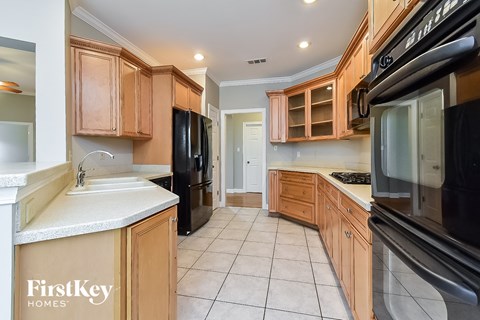 A kitchen with wooden cabinets and black appliances.