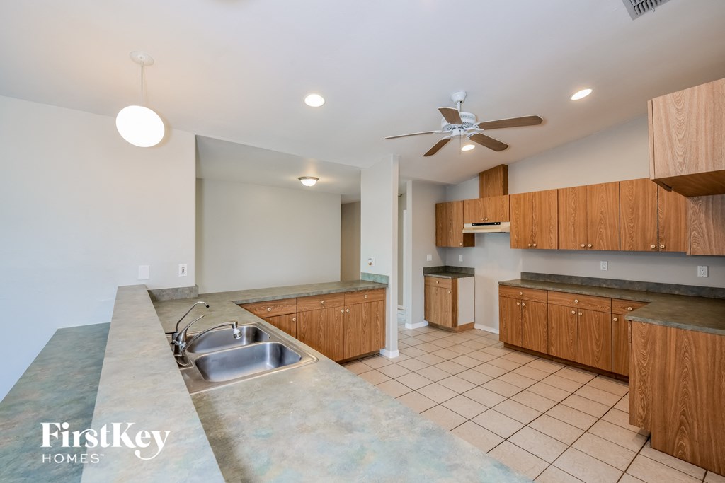 A kitchen with wooden cabinets and a concrete countertop.
