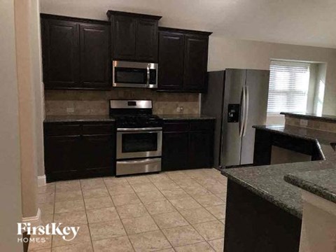 A kitchen with dark brown cabinets and stainless steel appliances.