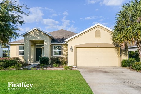 a beige house with a driveway and a garage door