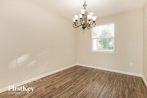 the dining room of a home with wood flooring and a chandelier