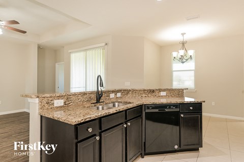 a kitchen with black cabinets and a granite counter top