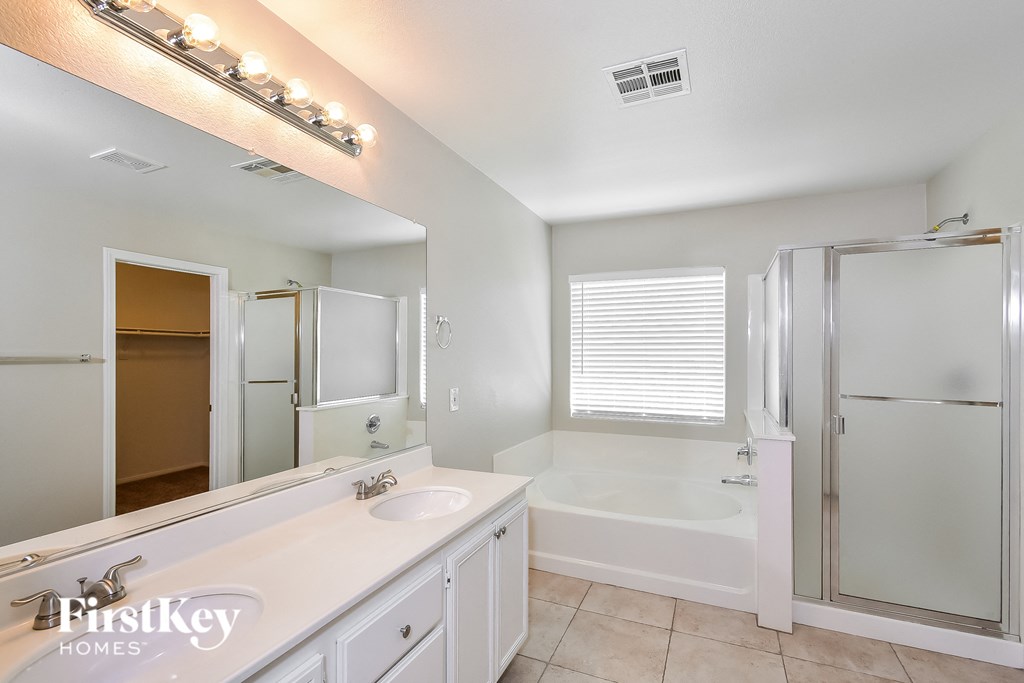 a bathroom with a sink and a tub and a shower and a mirror