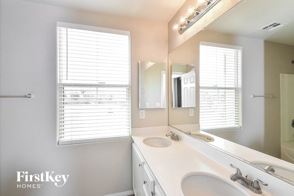 a bathroom with two sinks and a large mirror