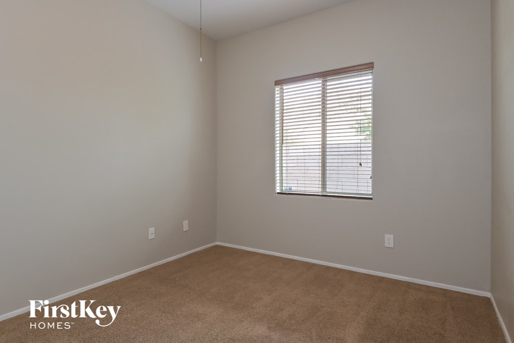 an empty room with a window and a carpet