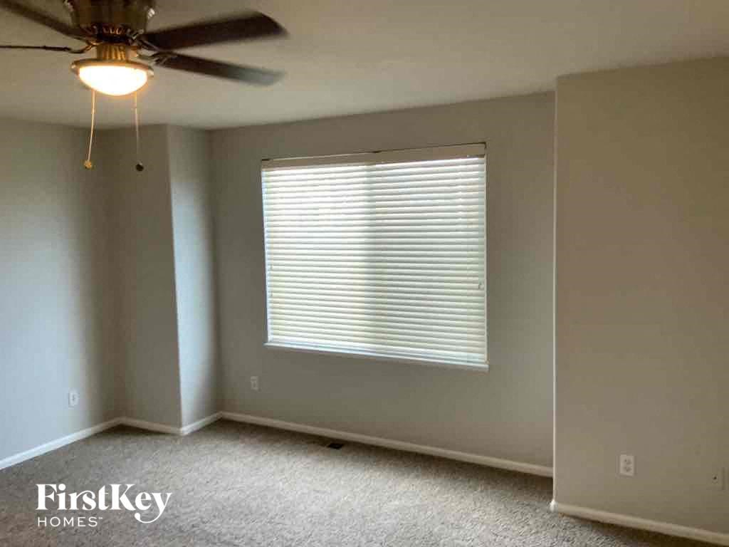 a bedroom with a ceiling fan and a window