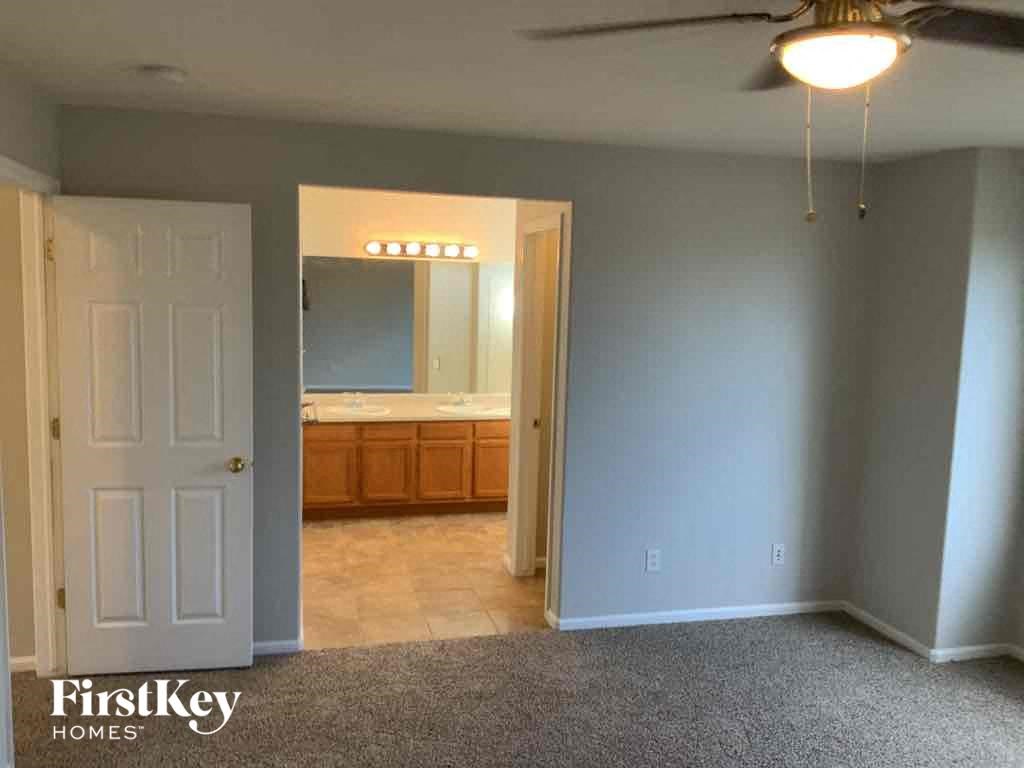 an empty living room with a bathroom and a ceiling fan