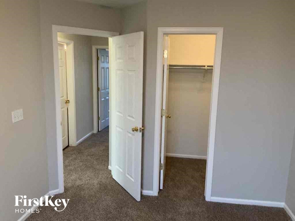 an empty bedroom with two closets and a door to a closet