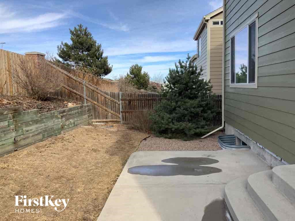 a backyard patio with a fence and a house