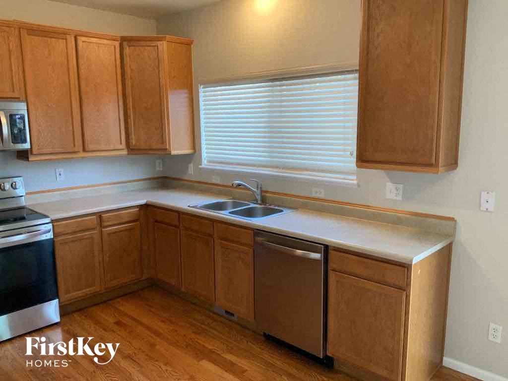 an empty kitchen with wooden cabinets and a sink
