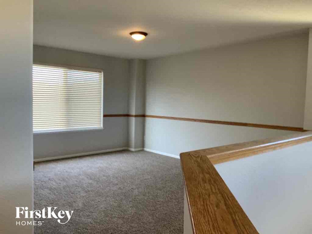 an empty living room with a wood railing and a window
