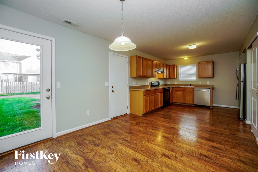 a kitchen and living room with wood flooring and a door to the backyard