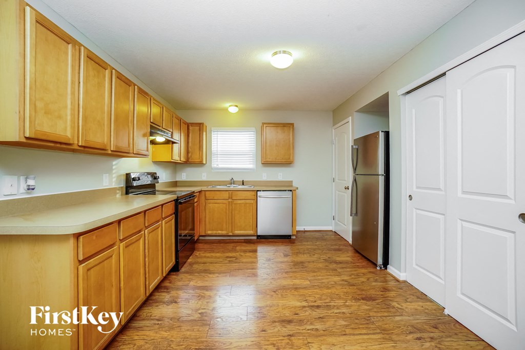 a kitchen with wooden cabinets and a stainless steel refrigerator