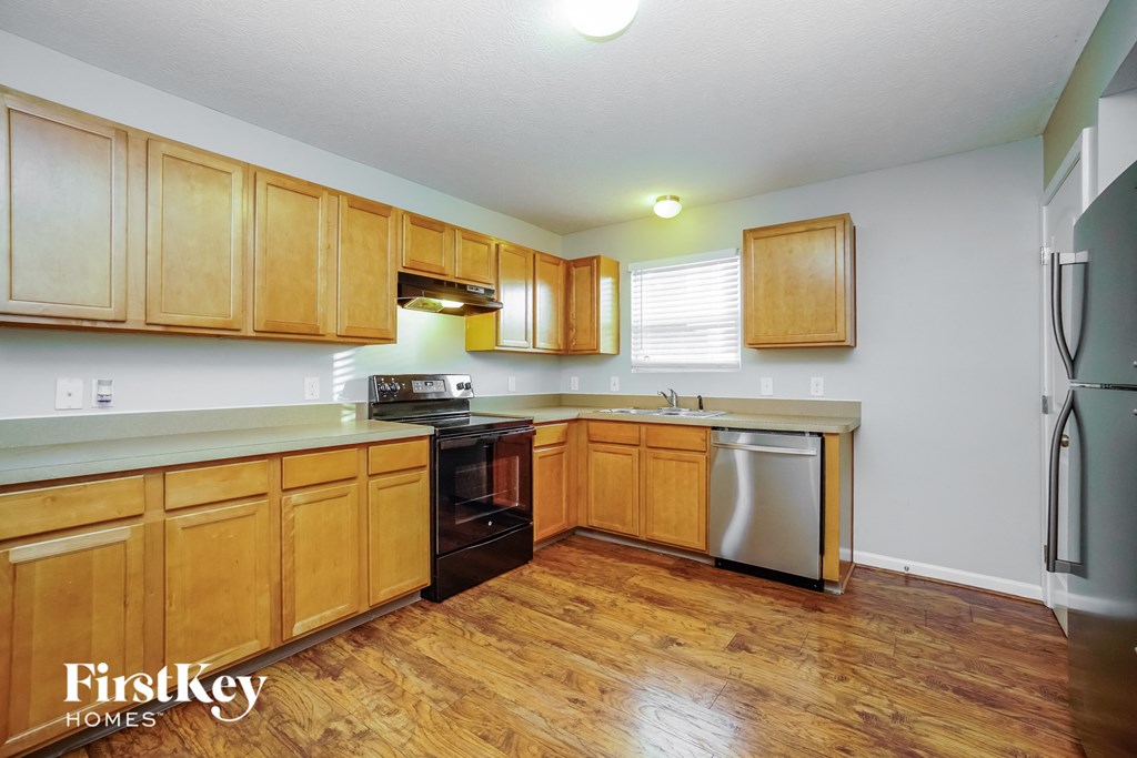 a kitchen with wood flooring and wooden cabinets