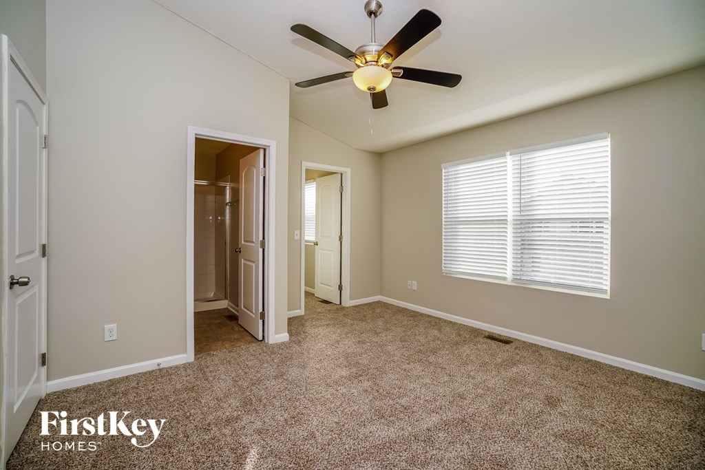 a bedroom with a ceiling fan and a door to a closet