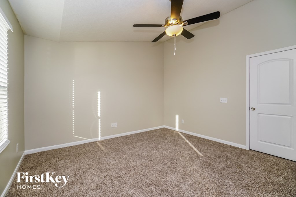 a bedroom with a ceiling fan and a carpeted floor