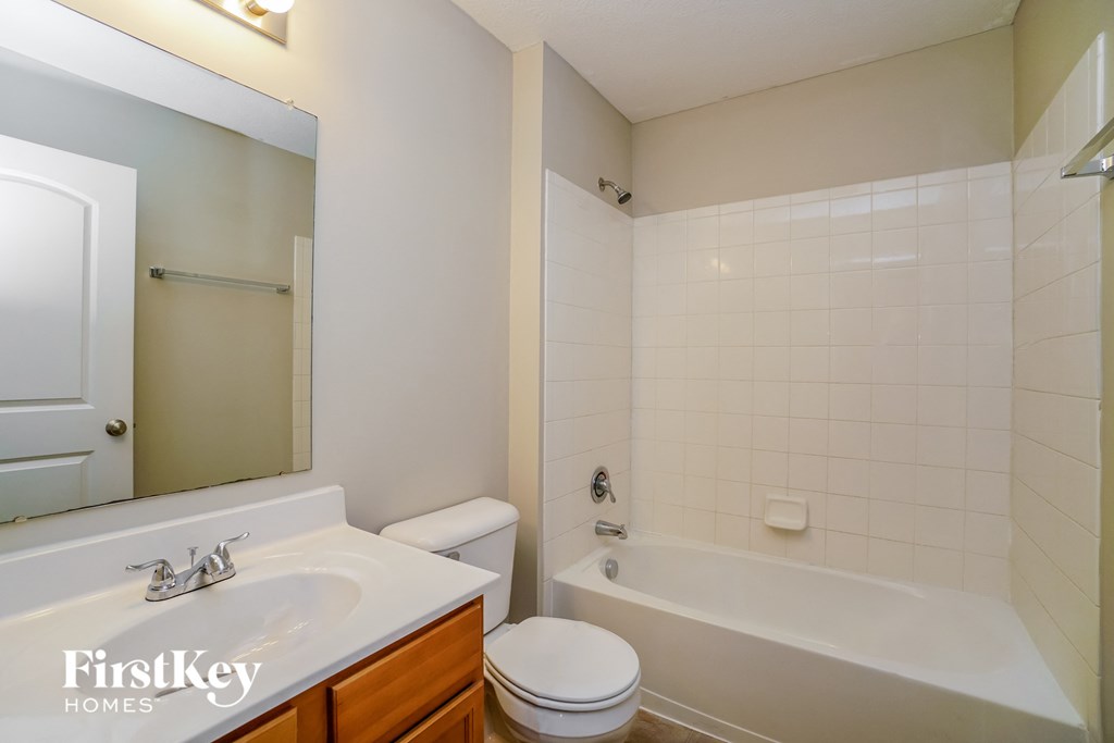 a bathroom with a sink toilet and tub and a mirror