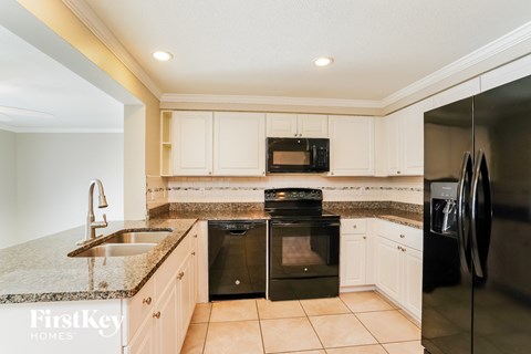 a kitchen with black appliances and white cabinets