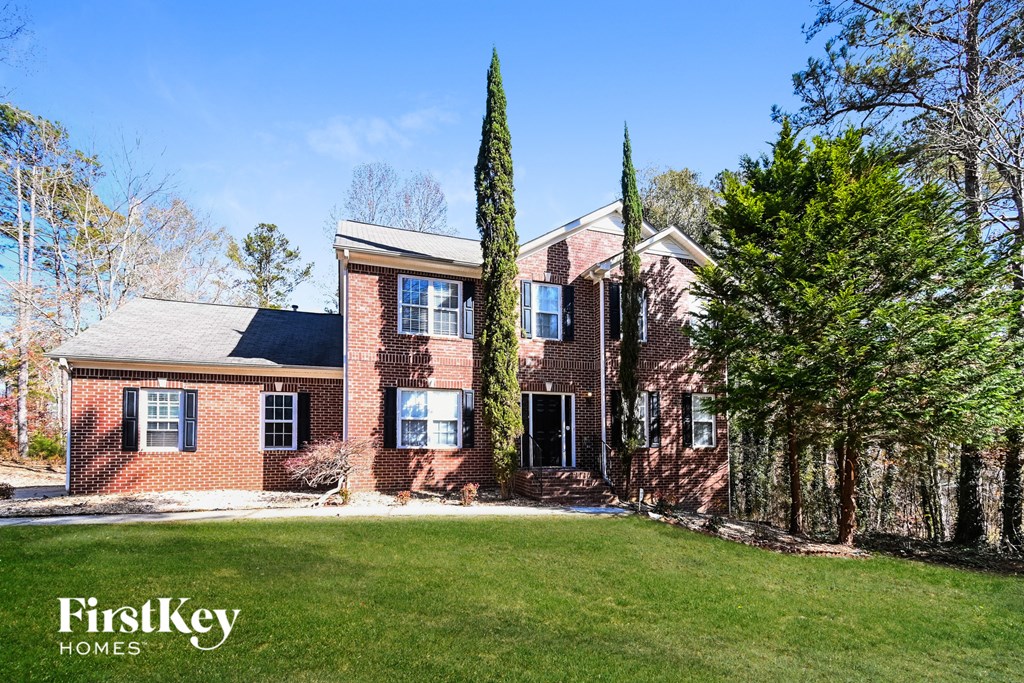 A brick house with a green lawn in front.