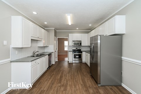 A kitchen with a refrigerator on the right side.