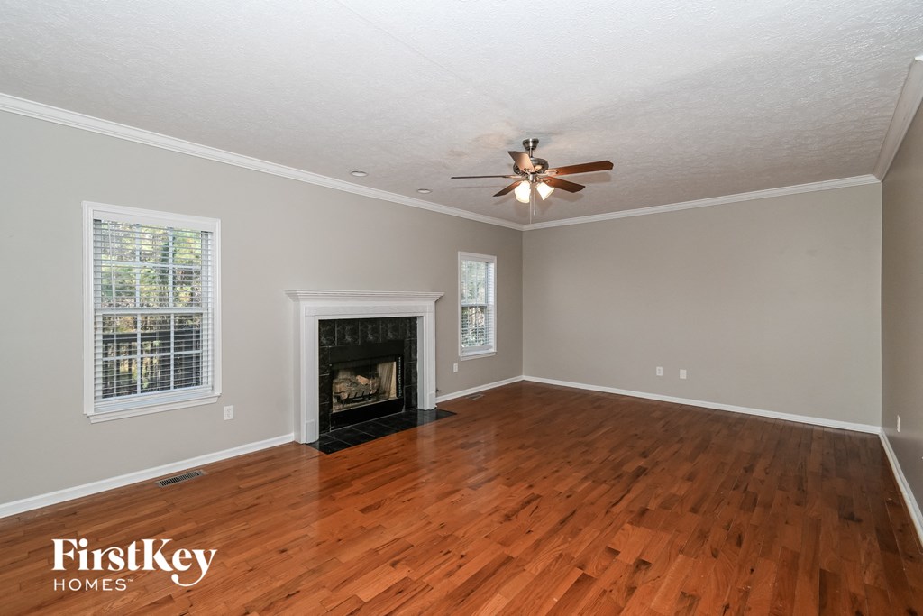 A room with a fireplace and a ceiling fan.