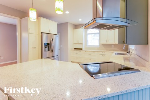 A kitchen with a granite countertop and a stainless steel sink.