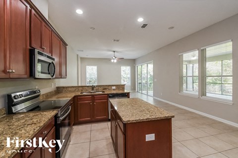 A kitchen with brown cabinets and granite countertops.