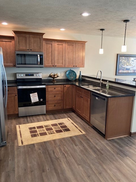 a kitchen with wooden cabinets and stainless steel appliances