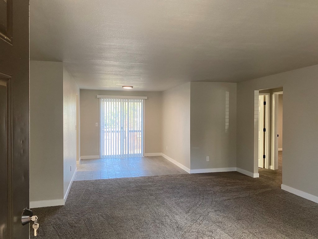 an empty living room with a sliding glass door