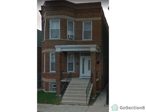 A brick house with a white door and a small porch.
