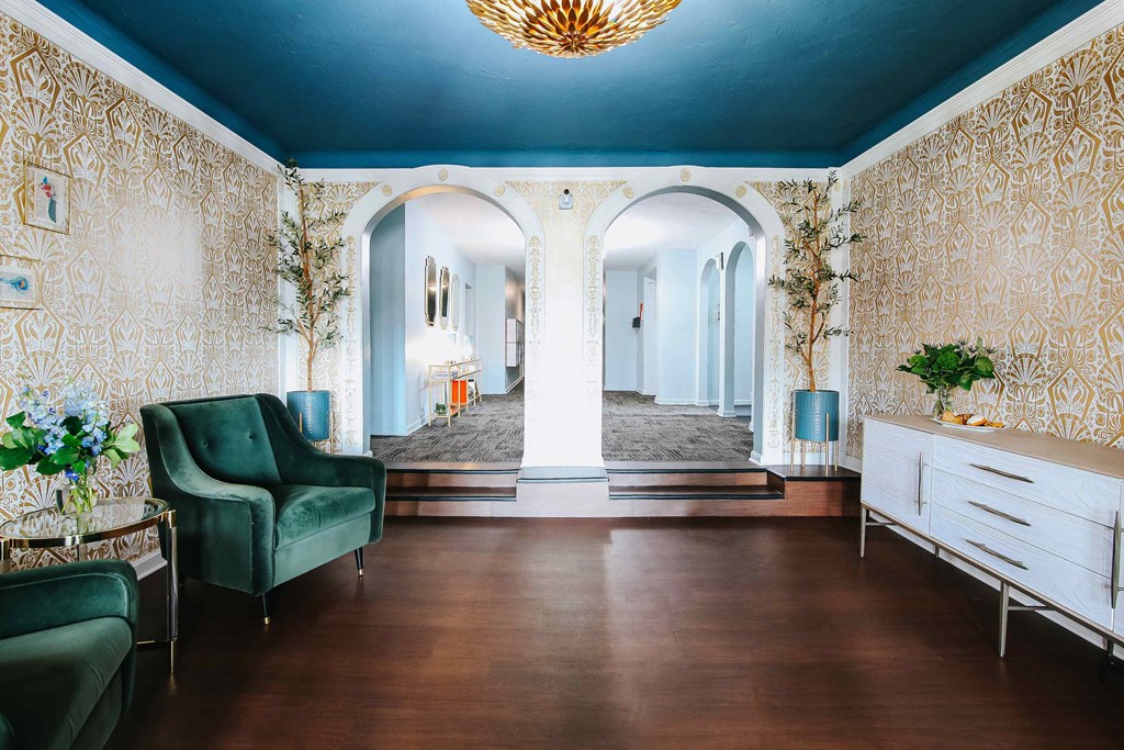 a living room with green furniture and a blue ceiling