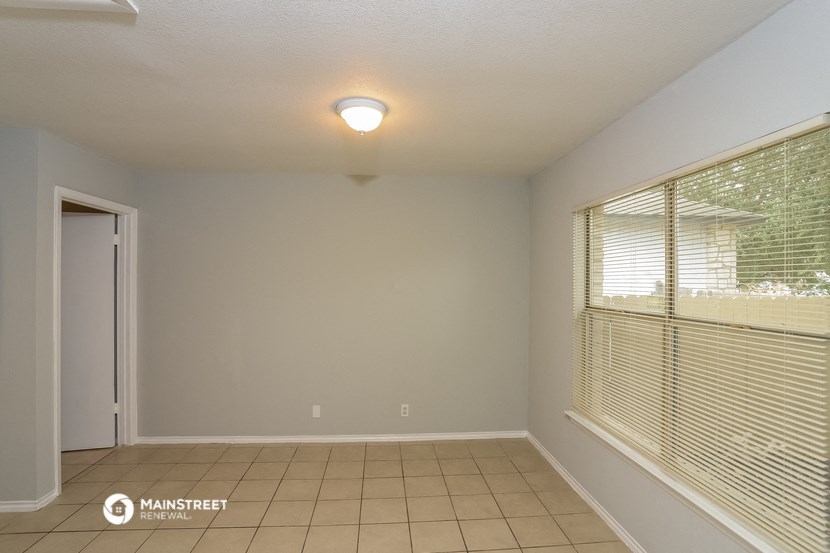 the living room of an empty house with a large window