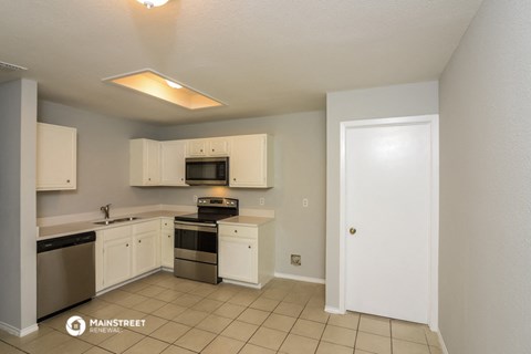 a kitchen with white cabinets and stainless steel appliances