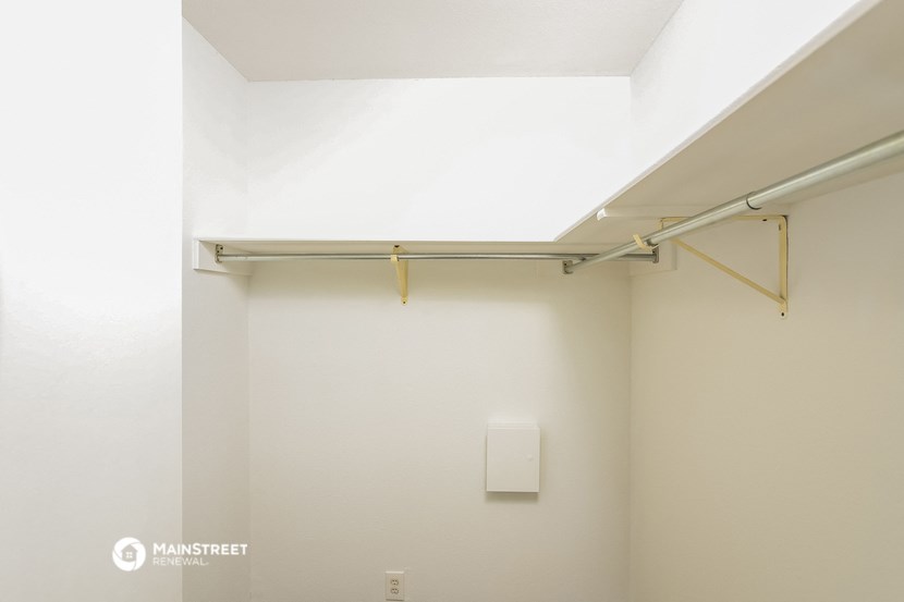 an empty room with a white wall and a white rack on the ceiling