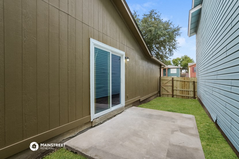 a backyard with a garage and a door to a house