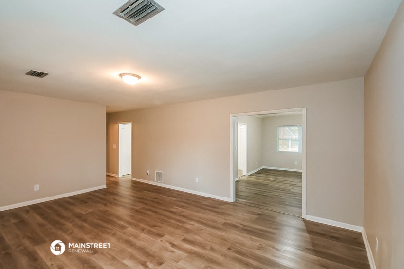 the spacious living room and dining room with hardwood flooring