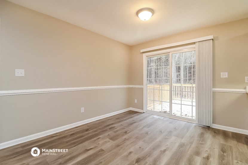 the spacious living room with a sliding glass door to the balcony