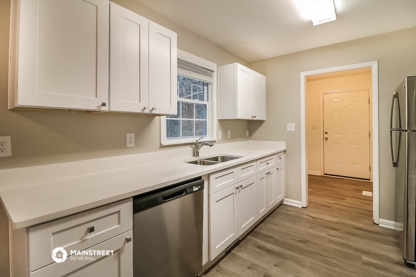 the kitchen of a home with white cabinets and stainless steel appliances