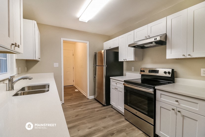 a kitchen with white cabinets and black appliances