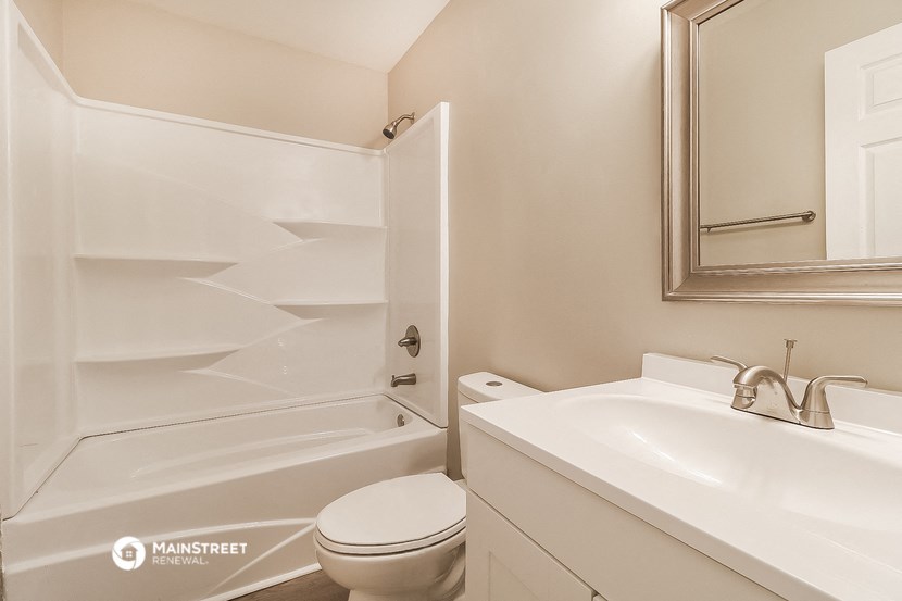 a bathroom with a toilet and a sink and a bath tub