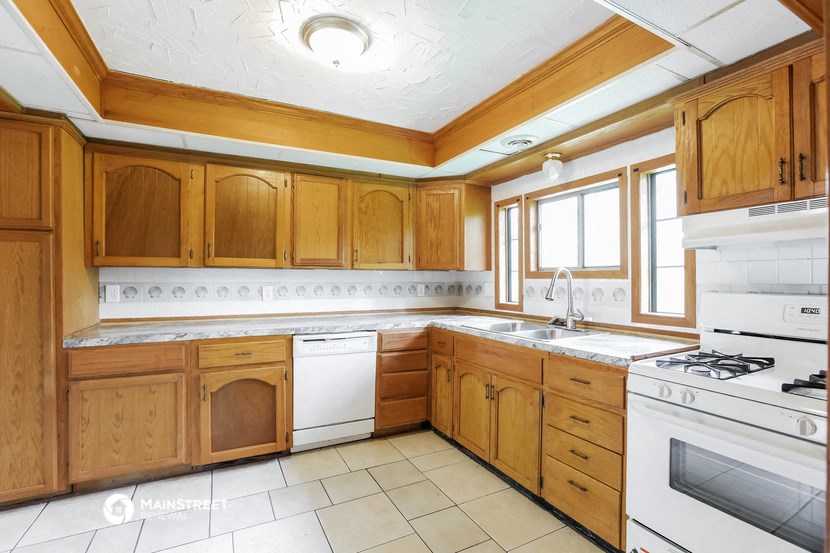 a kitchen with wooden cabinets and white appliances