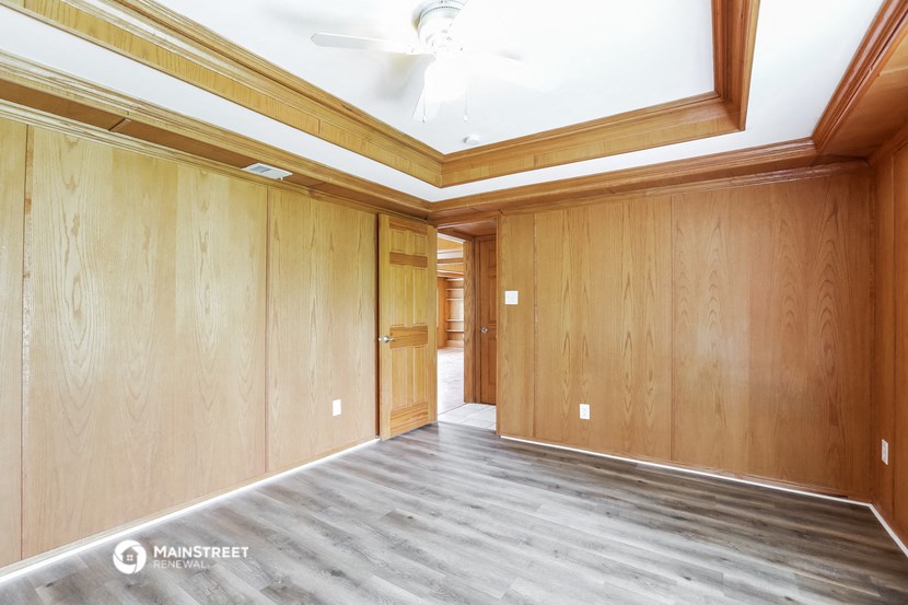 a living room with wood paneling and a ceiling fan