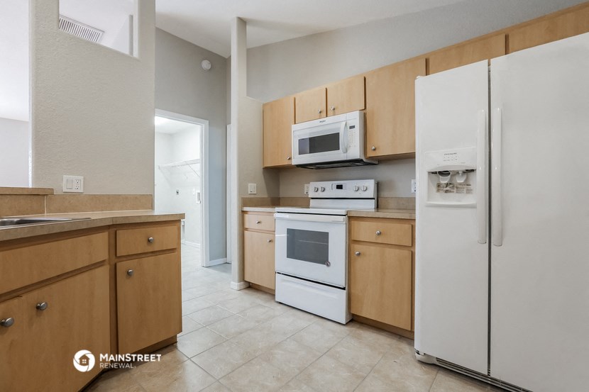 a kitchen with white appliances and wooden cabinets