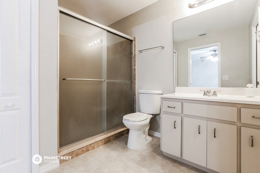 a white bathroom with a shower toilet and sink