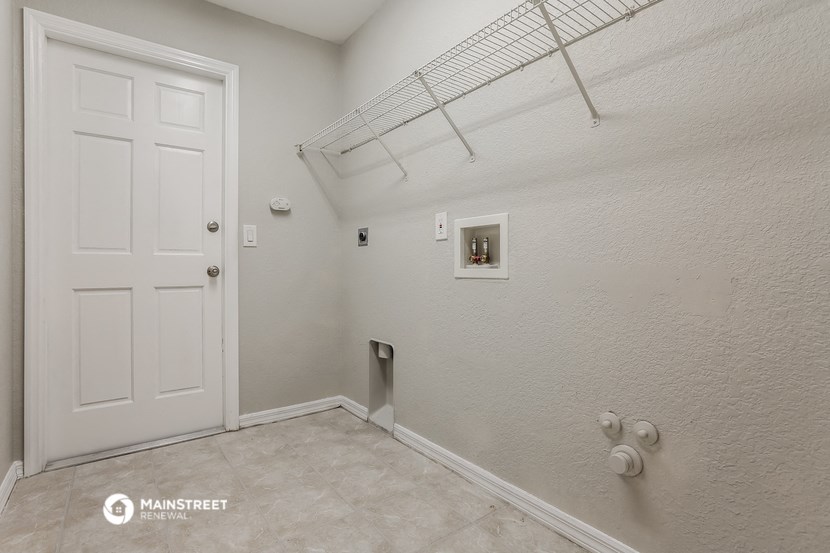 a white room with a white door and a closet with a rack on the wall